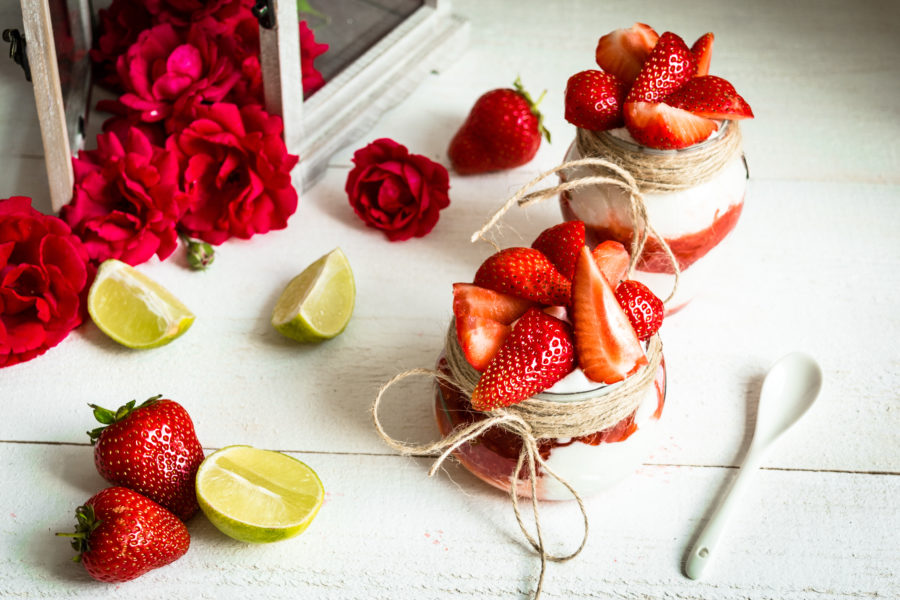 Снимка на десерт ягоди и сметана с украса от лайм и рози